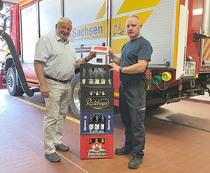 Bürgermeister Peter Mühle übergibt die Getränke in Neustadt an den Gerätewart Kay-Uwe Rehn (rechts)