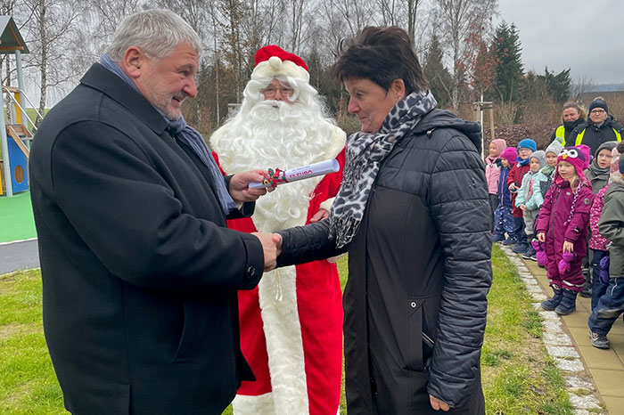 Bürgermeister Peter Mühle übergibt der Leiterin der Einrichtung Carola König im Beisein des Nikolauses und der Hohwaldbienen den Gutschein